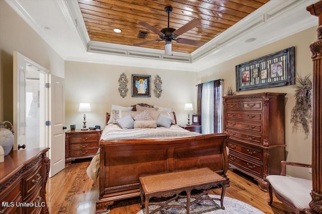 bedroom featuring wooden ceiling, light wood-type flooring, and a raised ceiling