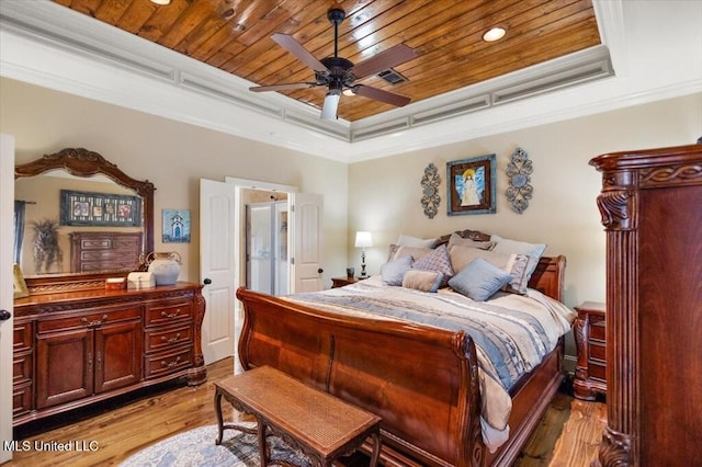 bedroom with a raised ceiling, wood finished floors, wooden ceiling, and ornamental molding