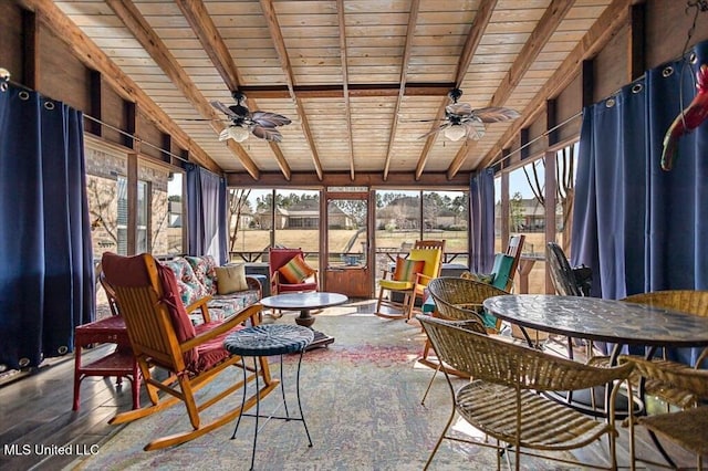 sunroom / solarium with lofted ceiling with beams, a wealth of natural light, ceiling fan, and wooden ceiling