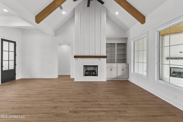 unfurnished living room with high vaulted ceiling, beamed ceiling, wood-type flooring, and ceiling fan