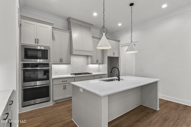 kitchen with a center island with sink, sink, pendant lighting, and dark hardwood / wood-style floors