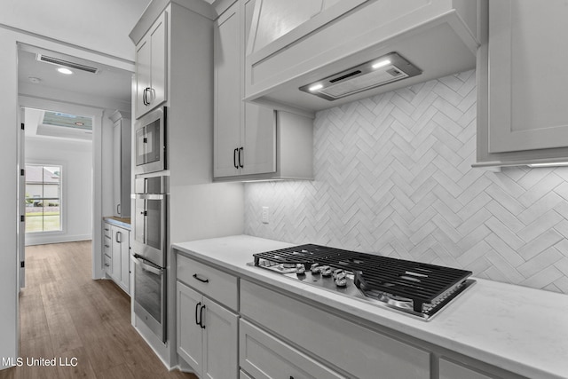 kitchen with tasteful backsplash, light stone countertops, stainless steel appliances, and dark wood-type flooring