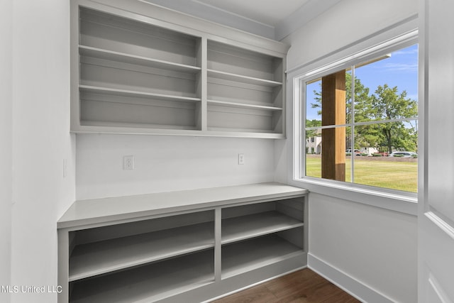 unfurnished office featuring crown molding and dark hardwood / wood-style floors