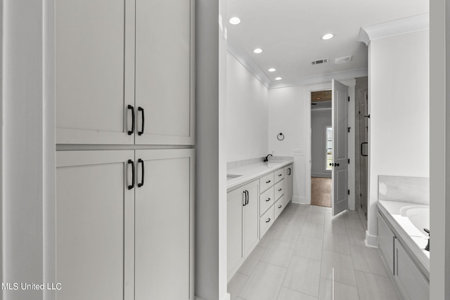 bathroom featuring vanity, a washtub, and tile patterned flooring