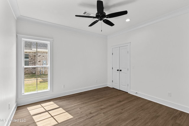 unfurnished room featuring dark wood-type flooring, ceiling fan, and crown molding