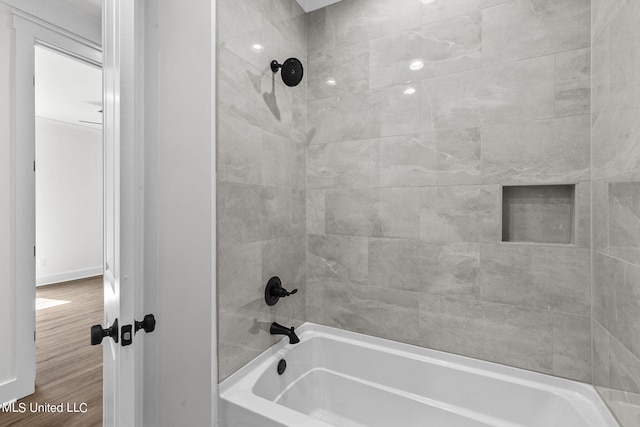 bathroom with tiled shower / bath combo and wood-type flooring