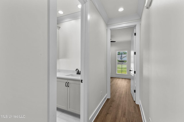 corridor with light hardwood / wood-style flooring and sink