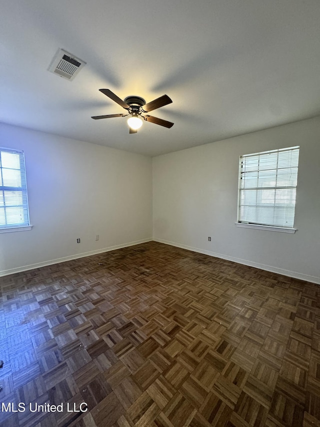 unfurnished room featuring ceiling fan, visible vents, and baseboards