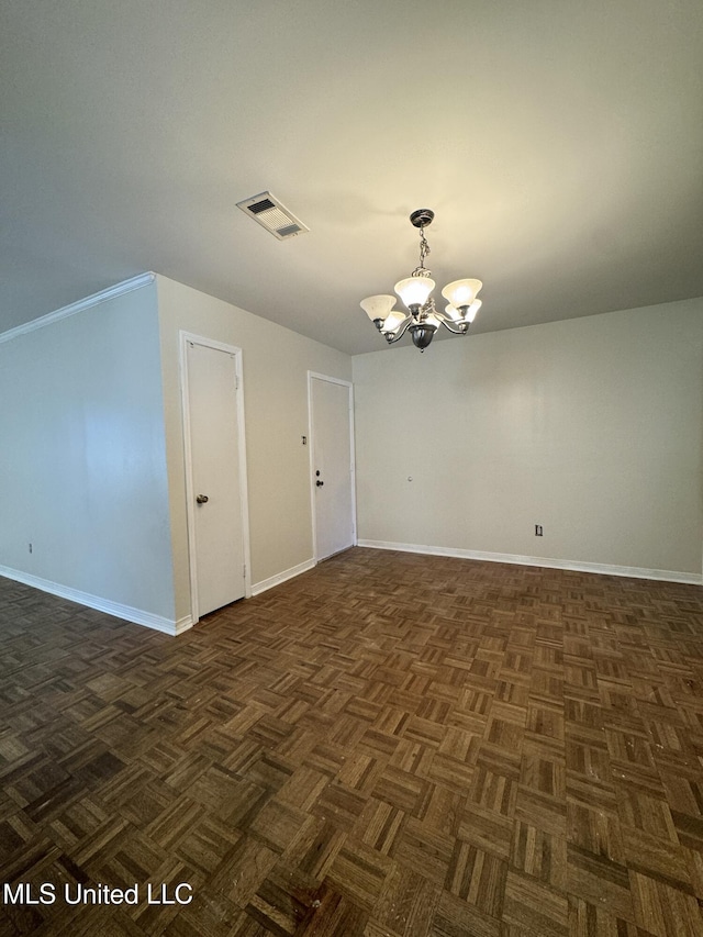 unfurnished room with baseboards, visible vents, and a notable chandelier