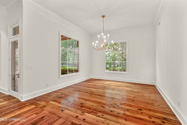 empty room with light hardwood / wood-style floors, crown molding, and an inviting chandelier