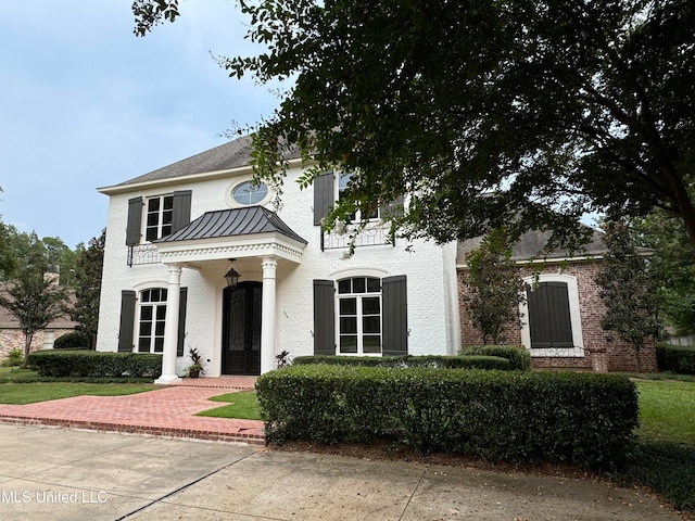 view of front of property with metal roof, stucco siding, and a standing seam roof