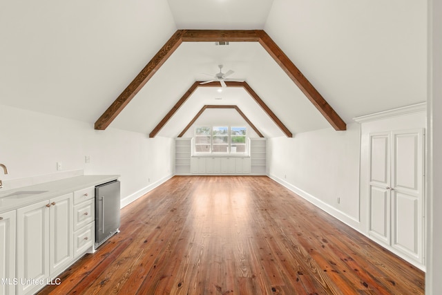 additional living space featuring sink, ceiling fan, lofted ceiling with beams, and dark hardwood / wood-style flooring