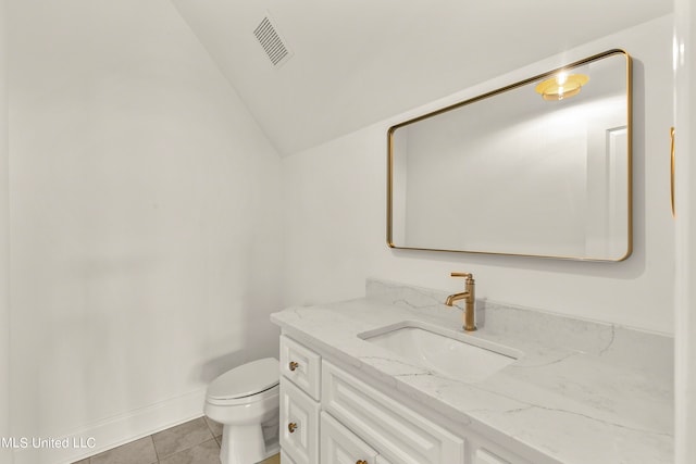 bathroom featuring vanity, lofted ceiling, toilet, and tile patterned floors