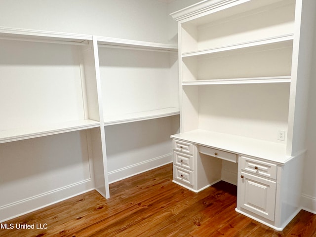 interior space with built in desk and dark wood-type flooring