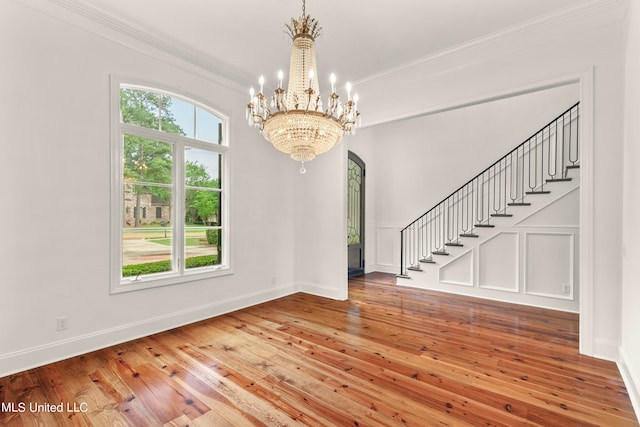 entryway featuring ornamental molding, hardwood / wood-style flooring, and a chandelier