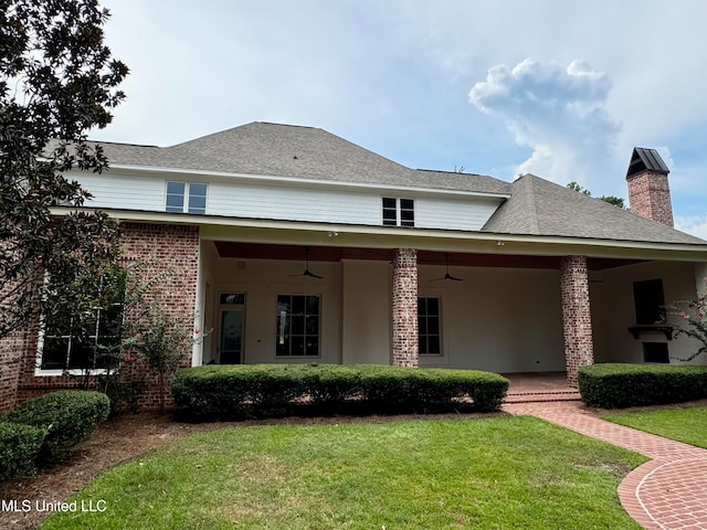 view of front of property featuring ceiling fan, a front yard, and a patio area