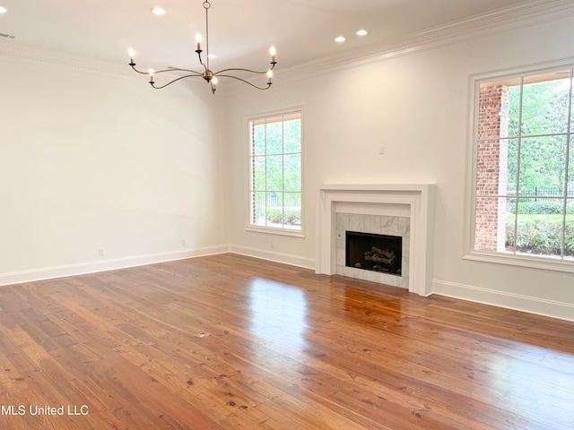 unfurnished living room featuring crown molding, wood-type flooring, and plenty of natural light