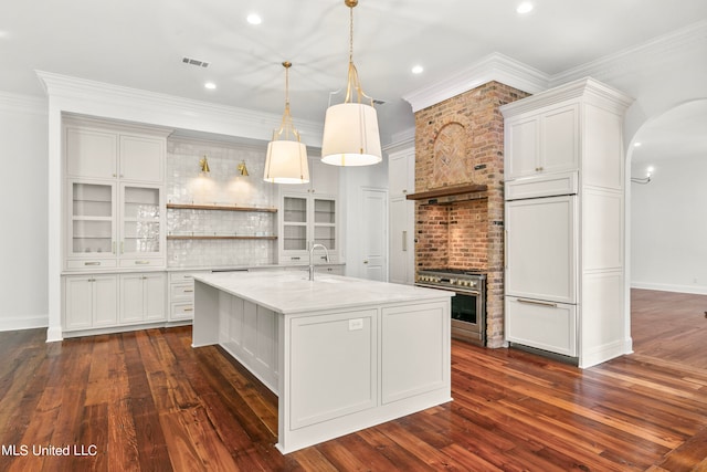 kitchen with dark wood-type flooring, white cabinets, hanging light fixtures, and backsplash