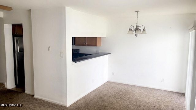 3230 Cumberland Rd Unit 78, Ocean Springs, MS 39564 - kitchen with carpet, a chandelier, dark countertops, freestanding refrigerator, and decorative light fixtures