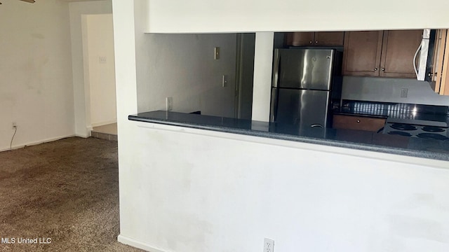 3230 Cumberland Rd Unit 78, Ocean Springs, MS 39564 - kitchen with stainless steel appliances, a peninsula, dark brown cabinets, dark countertops, and carpet floors