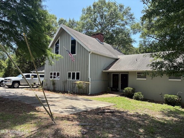 6825 Shore Dr, Ocean Springs, MS 39564 - view of front of property featuring board and batten siding, roof with shingles, and a chimney