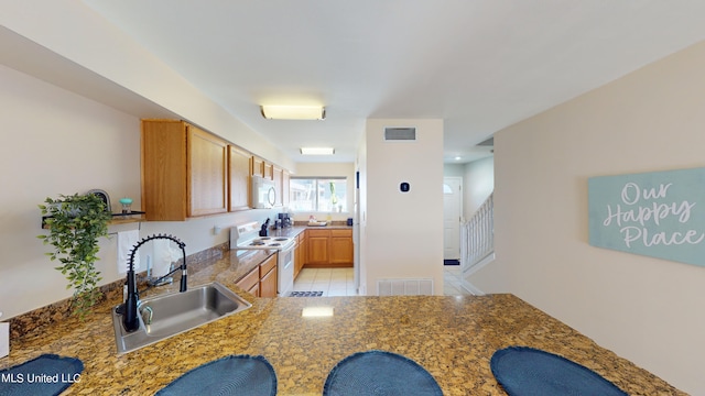 kitchen featuring sink, white appliances, and light tile patterned floors