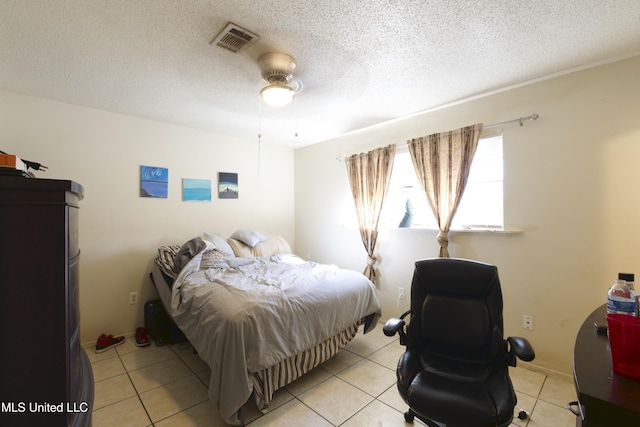 tiled bedroom with ceiling fan and a textured ceiling