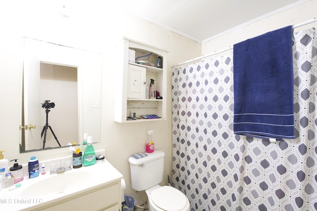 bathroom featuring toilet, crown molding, walk in shower, and vanity