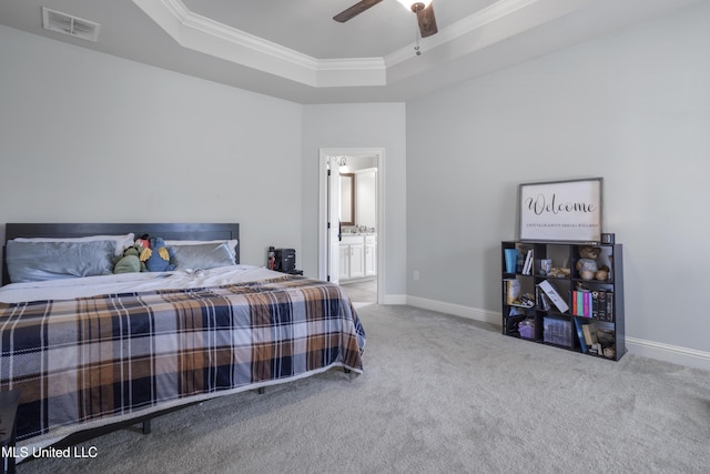 bedroom with baseboards, visible vents, carpet floors, ornamental molding, and a raised ceiling