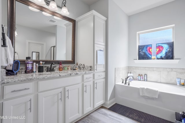 full bath featuring a bath, visible vents, and vanity