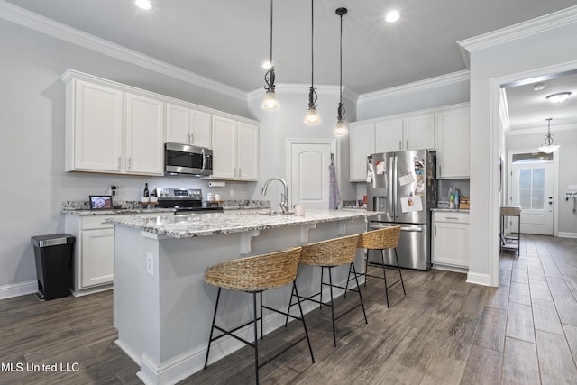 kitchen with dark wood finished floors, ornamental molding, stainless steel appliances, white cabinetry, and a kitchen island with sink