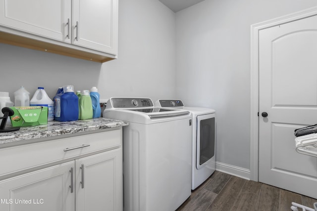 laundry room featuring cabinet space, washing machine and dryer, baseboards, and dark wood-style flooring