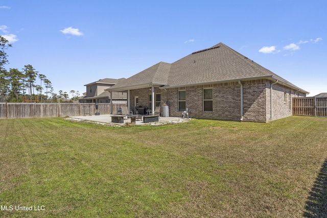 rear view of house with brick siding, a patio area, a lawn, and a fenced backyard