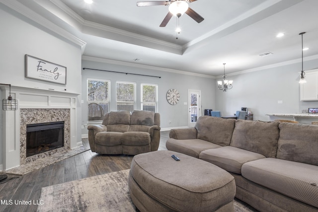 living area featuring visible vents, a fireplace, dark wood-style flooring, crown molding, and a raised ceiling