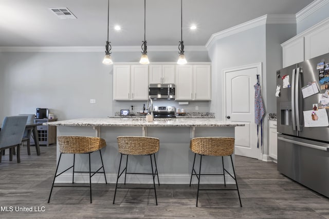 kitchen with visible vents, white cabinets, stainless steel appliances, and a breakfast bar area