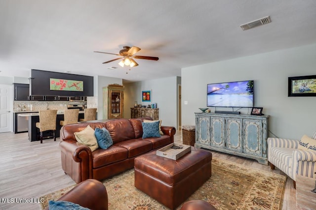 living area featuring light wood finished floors and ceiling fan