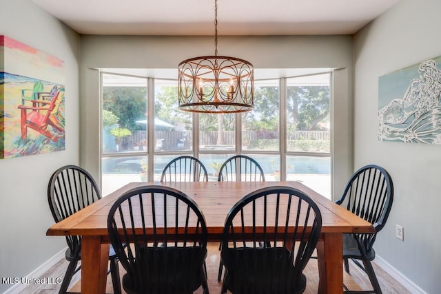 dining room featuring baseboards, a chandelier, and plenty of natural light