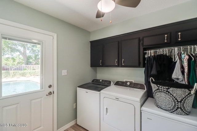 laundry room featuring separate washer and dryer, cabinet space, ceiling fan, and baseboards