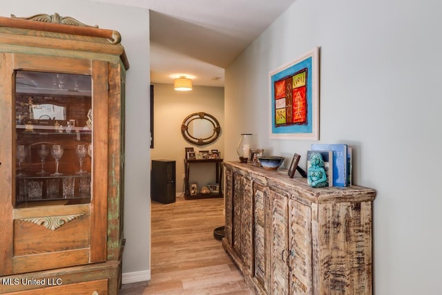 hallway with light wood-style flooring and baseboards
