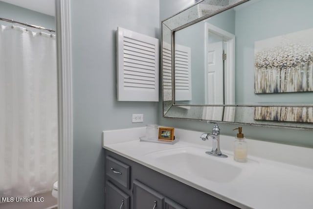 full bathroom with vanity, toilet, and curtained shower