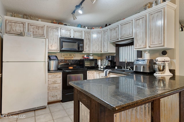 kitchen featuring a textured ceiling, a sink, a toaster, black appliances, and a peninsula
