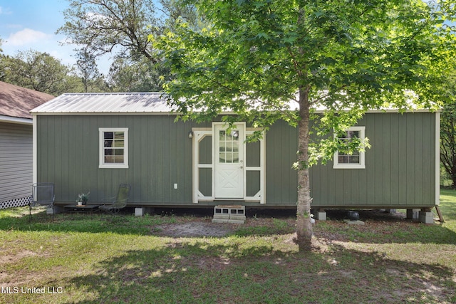 view of front facade featuring metal roof and a front yard