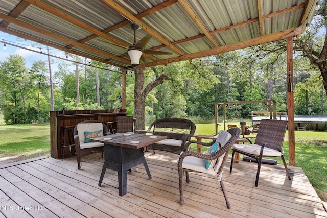 wooden deck with ceiling fan and a yard