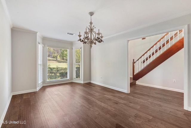 spare room with crown molding, dark hardwood / wood-style flooring, and an inviting chandelier