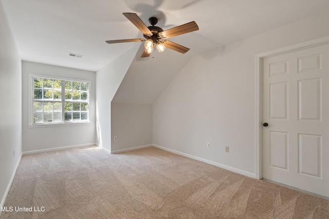 additional living space with ceiling fan, vaulted ceiling, and light colored carpet