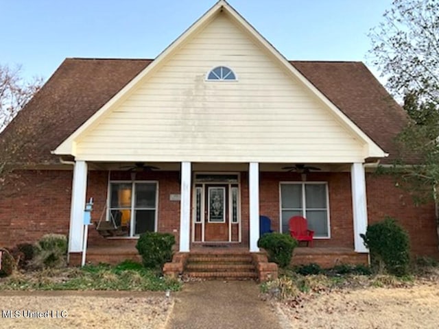 view of front of house with covered porch, brick siding, and ceiling fan