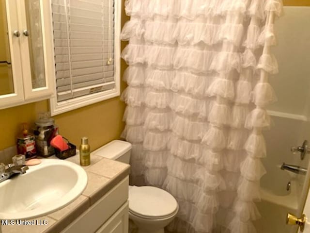 full bath featuring toilet, shower / bath combo with shower curtain, and vanity