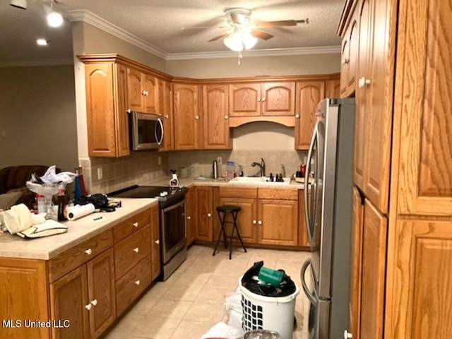 kitchen featuring light tile patterned floors, a sink, a ceiling fan, appliances with stainless steel finishes, and backsplash