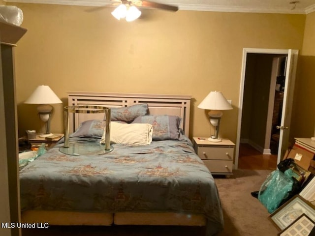 carpeted bedroom with ornamental molding and ceiling fan