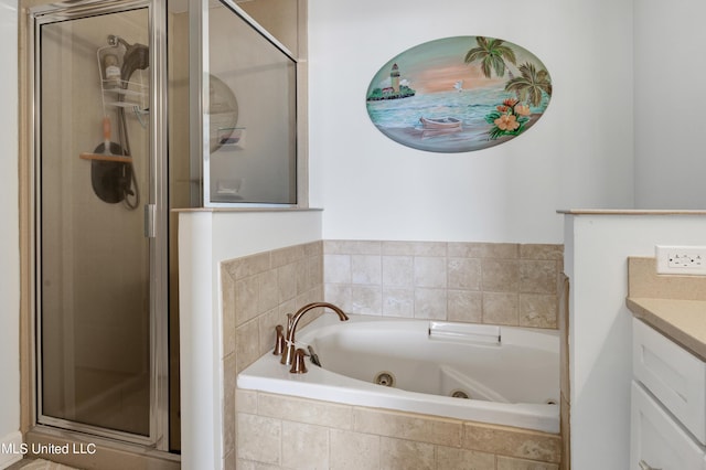bathroom with a jetted tub, vanity, and a stall shower
